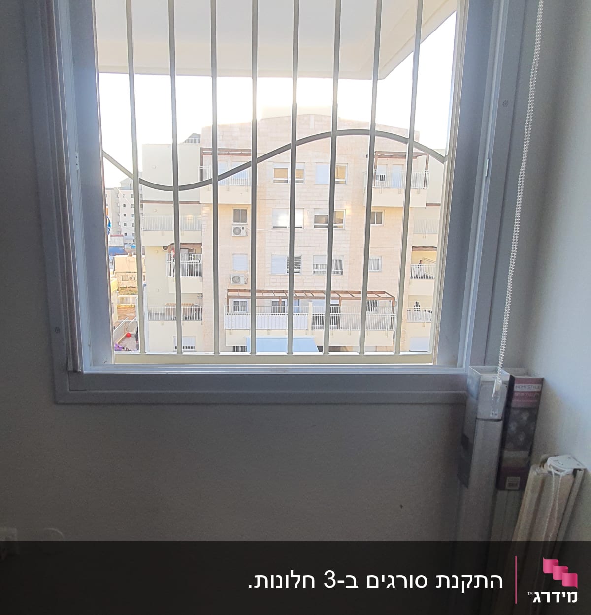 חלון עם סורגים לבנים ומסגרת לבנה